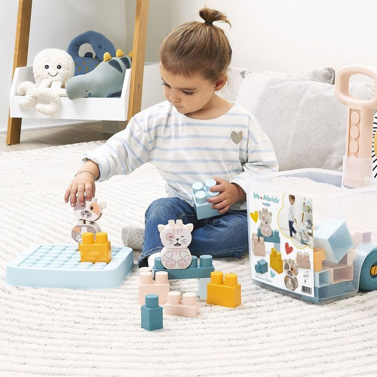 Una bambina gioca con blocchi colorati sul pavimento.