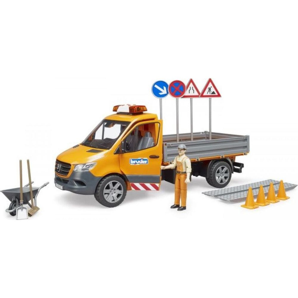 Żółta ciężarówka z pracownikiem, znakami, pachołkami i taczką.