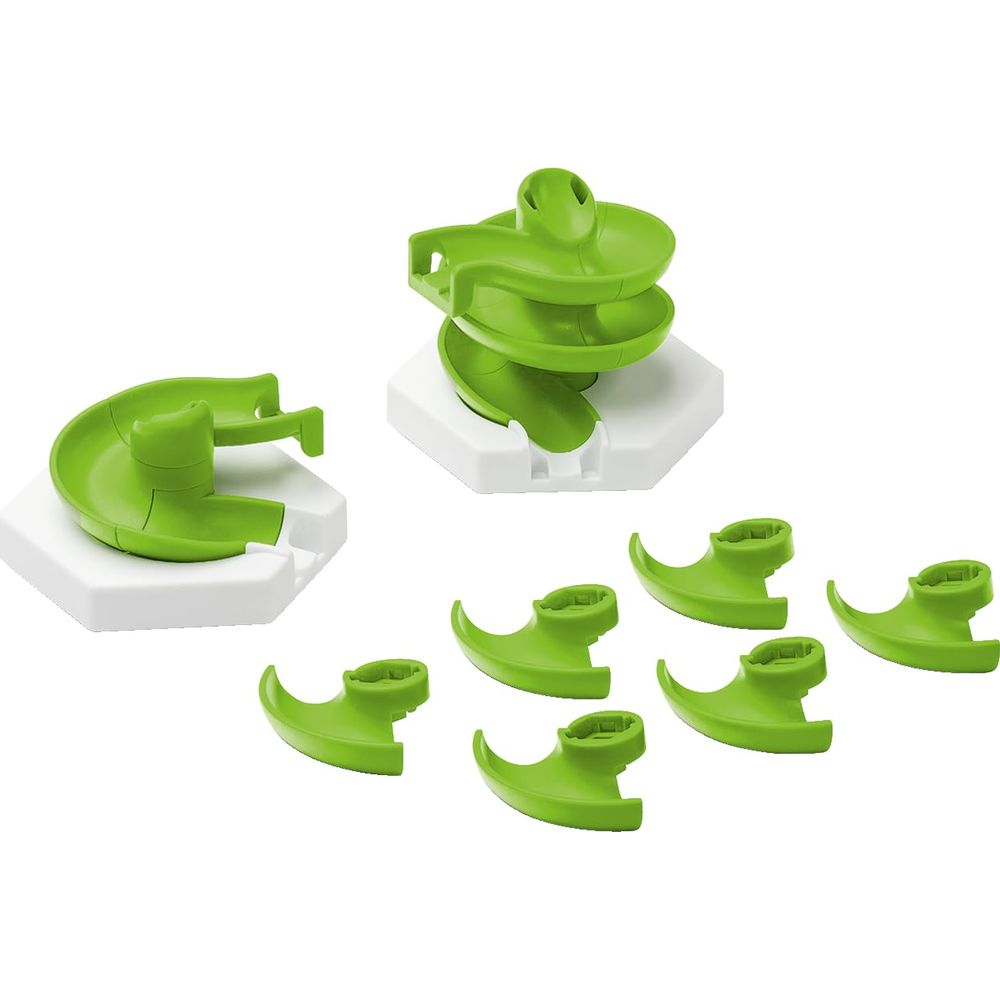 Groene speelgoed glijbaanonderdelen op witte sokkels, op witte achtergrond.
