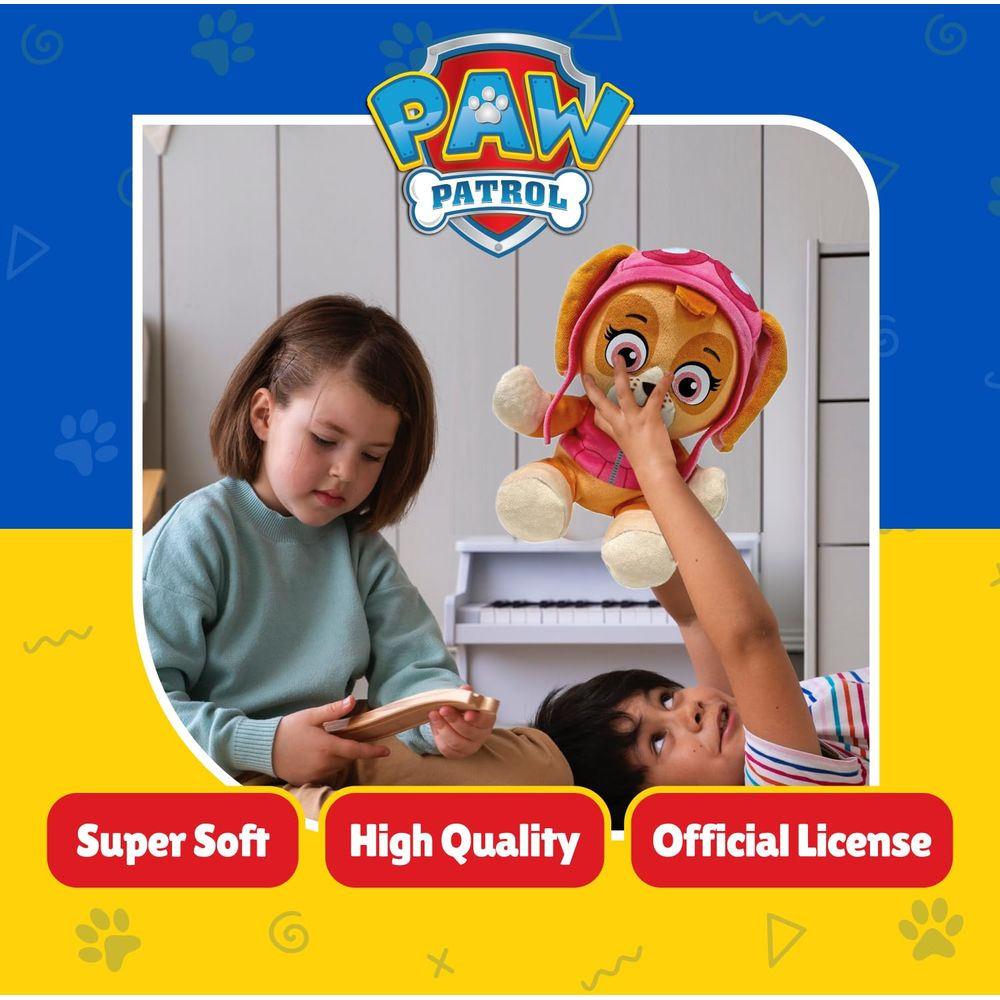 Bambini giocano con un peluche Paw Patrol davanti a un pianoforte bianco.