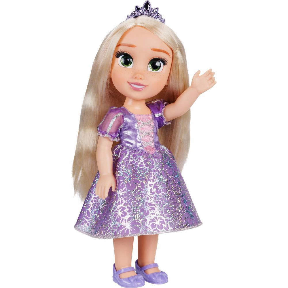 Una muñeca con pelo rubio largo, tiara y vestido lila saluda.