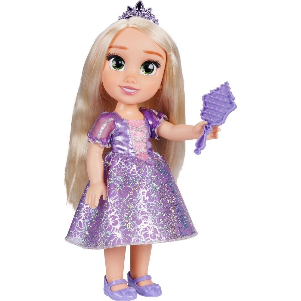Una muñeca con pelo rubio largo, tiara y vestido lila sostiene un cepillo lila.