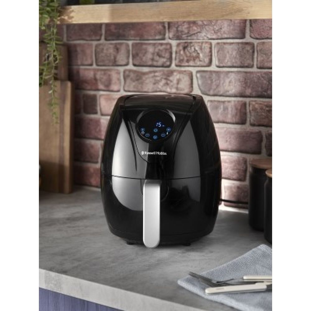 Friggitrice ad aria Russell Hobbs nera con display digitale su un piano.