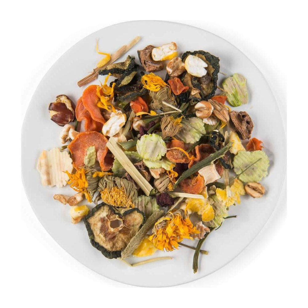 Un plato blanco lleno de una mezcla de frutas secas, verduras y hierbas.
