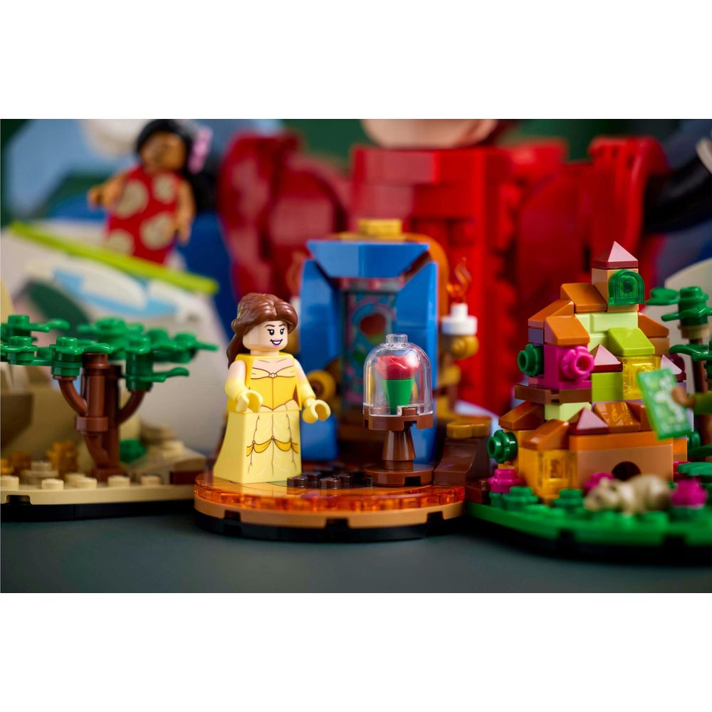 Sarı elbiseli Belle, cam fanus altındaki gülün yanında duruyor, Lego seti.