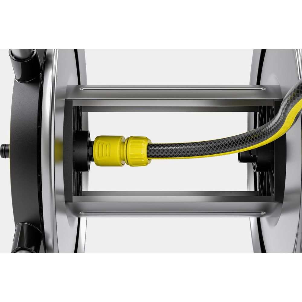 Czarny wąż z żółtymi paskami jest przymocowany do bębna na wąż.