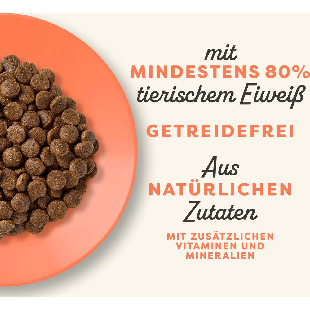 Brązowa karma dla zwierząt na pomarańczowym talerzu z niemieckim tekstem.