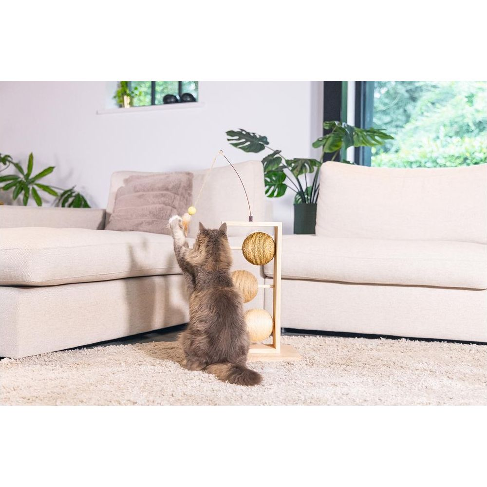 Eine graue Katze spielt mit einem Spielzeug an einem Kratzbaum mit Kugeln.