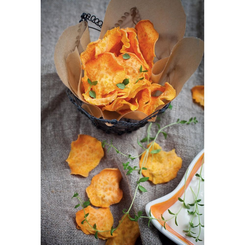 Geröstete Süßkartoffelchips mit Kräutern in einem Korb und auf einem Tuch.