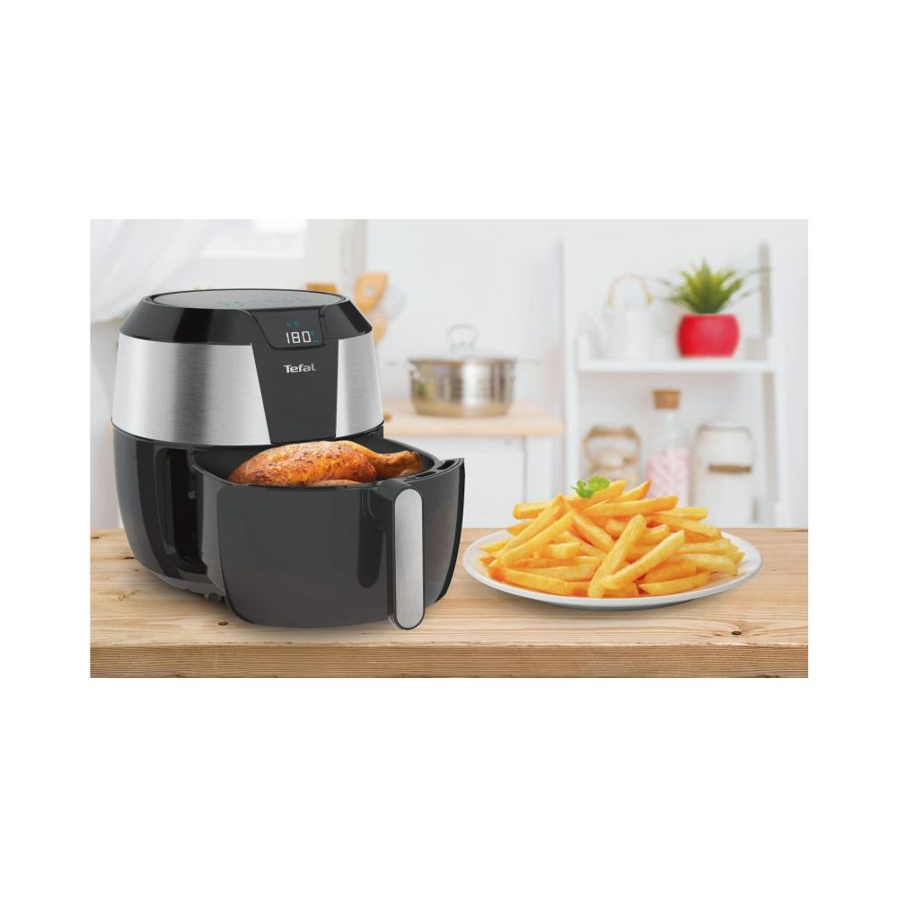 Eine Tefal Heißluftfritteuse mit einem Hähnchenschenkel und Pommes Frites.