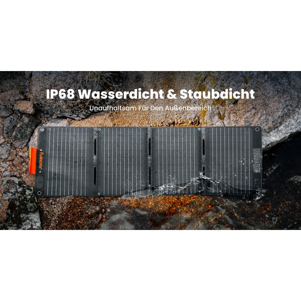 Ein aufklappbares Solarmodul liegt im Wasser auf Steinen. Es ist schwarz mit weißen Linien.