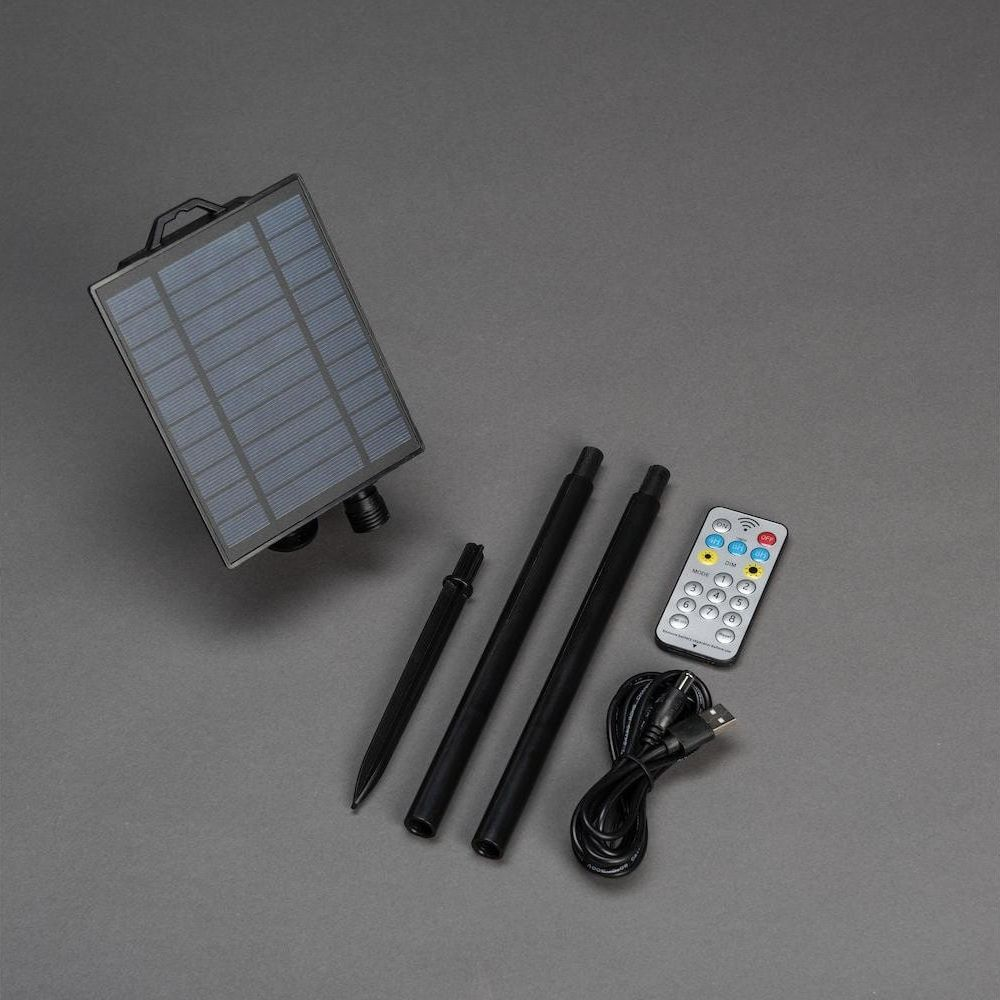 Solarpanel, Erdspieße, Fernbedienung und USB-Kabel auf grauem Hintergrund.