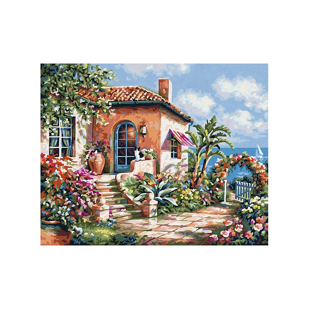 Una casa mediterranea con fiori in fiore, un gatto e il mare sullo sfondo.