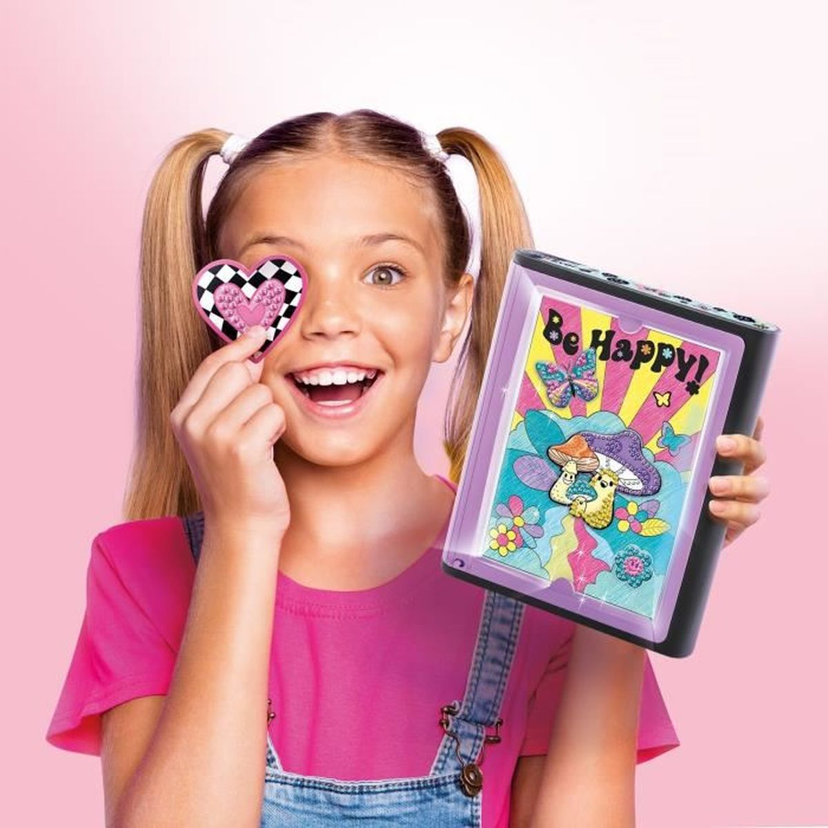 Dziewczynka trzyma naklejkę w kształcie serca przed okiem, pokazuje podświetlany obrazek.