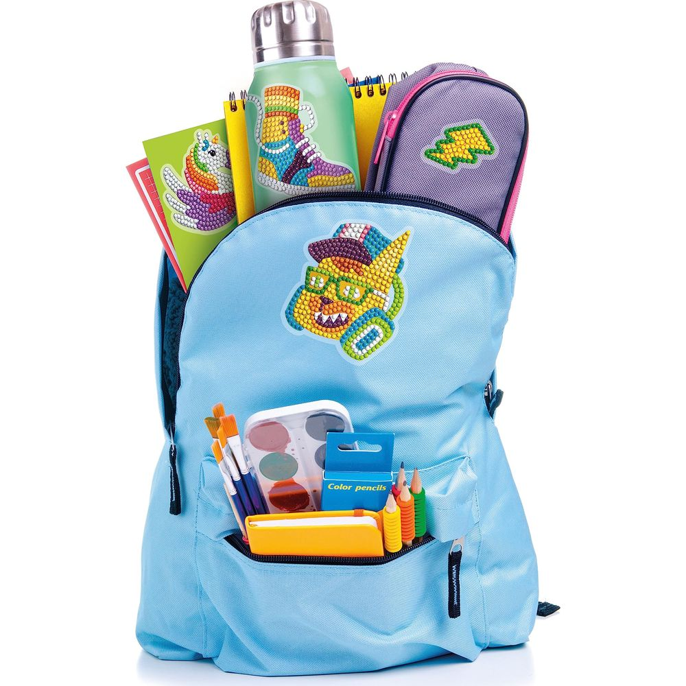 Jasnoniebieski plecak wypełniony artykułami szkolnymi, w tym kredkami, farbami i bidonem.