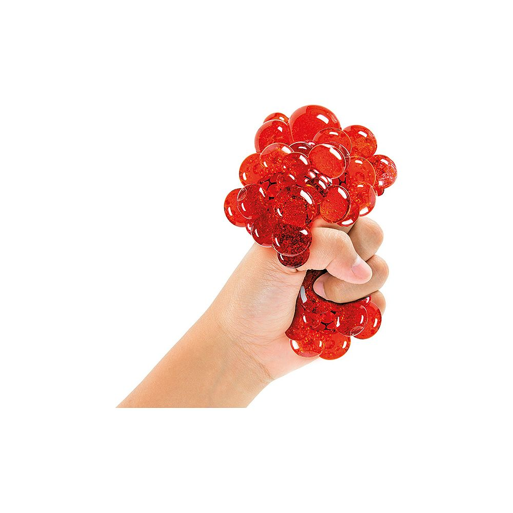 Eine Hand zerquetscht einen roten, glitzernden Ball aus vielen kleinen Kugeln.