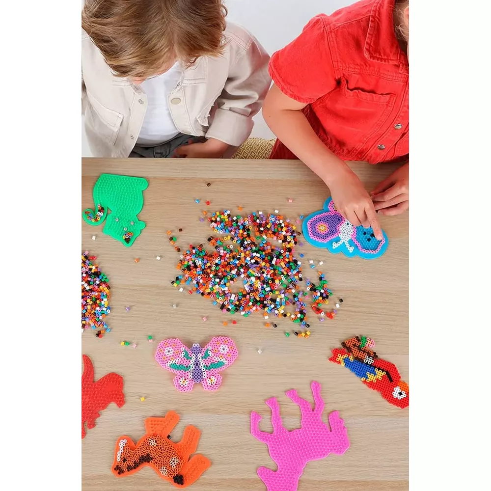 Kinder basteln mit bunten Perlen tiere und figuren auf holztisch.