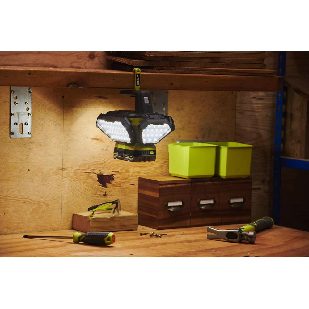 Une lumière de travail pivotante et lumineuse à deux têtes pend d'une étagère en bois.