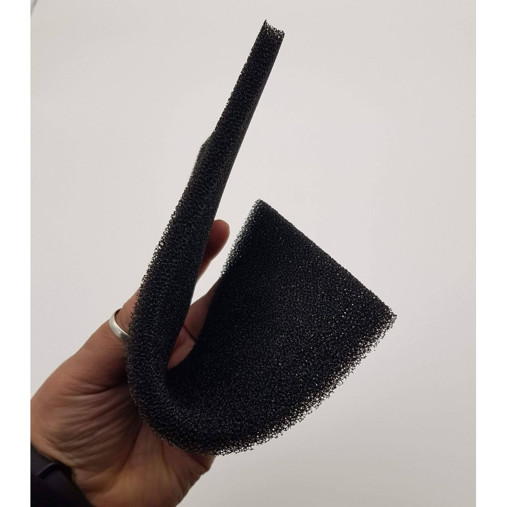 Schwarzer Schaumstoff wird von einer Hand mit einem Ring gehalten.