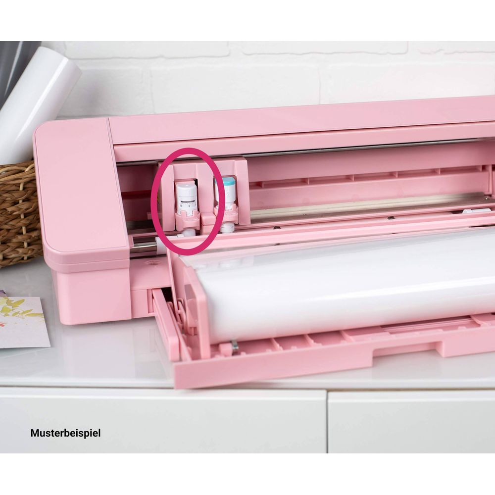 Rosa Schneideplotter mit zwei Klingenhalterungen und einer weißen Rolle.