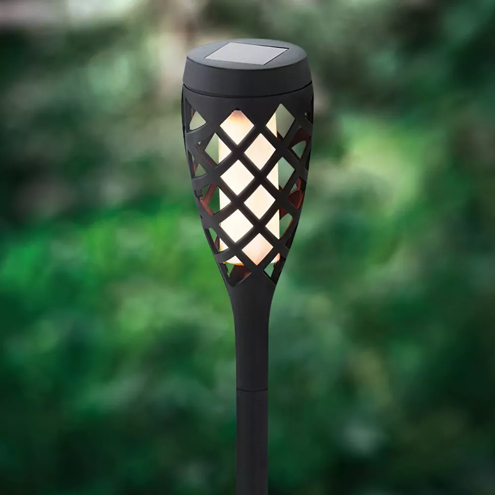 Schwarze Solartaschenlampe mit Flammenlichteffekt im Garten.