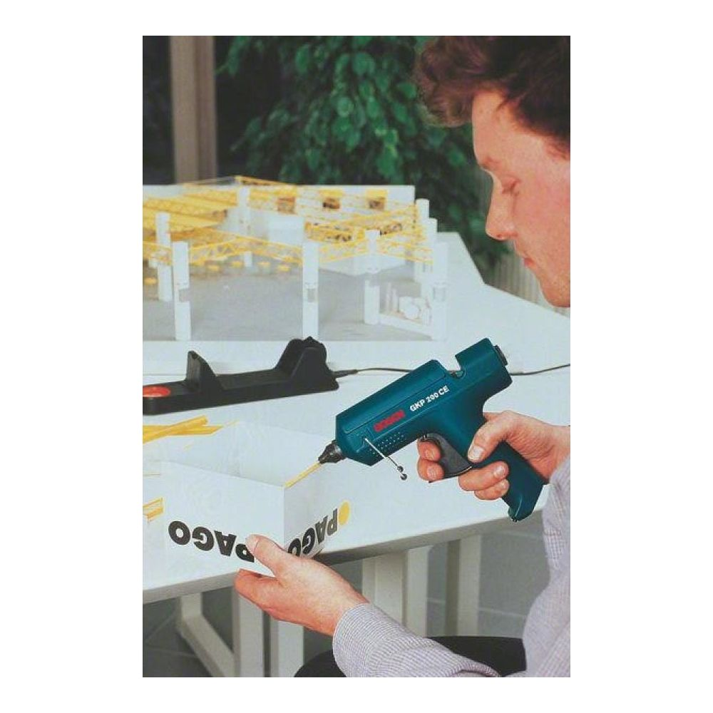 Mężczyzna używa pistoletu do klejenia na gorąco na modelu.