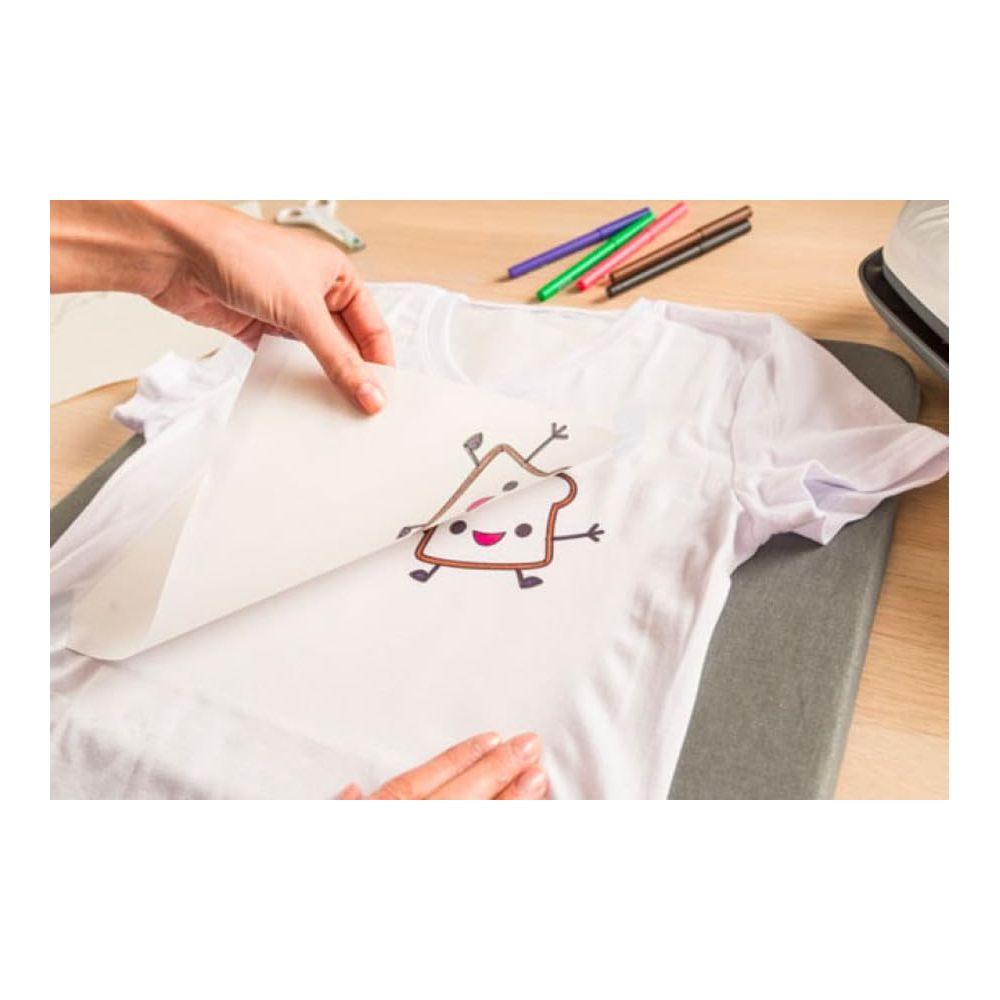 Hände legen Transferpapier mit Toast-Design auf weißes T-Shirt.