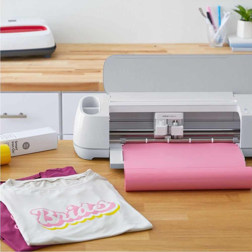 Ein Schneideplotter schneidet rosa Material für ein T-Shirt mit dem Aufdruck „Bride“.