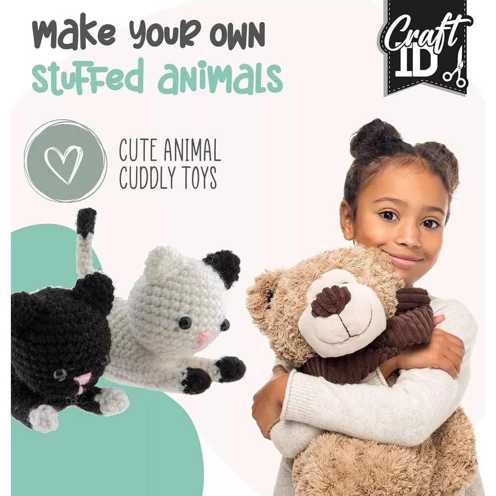 Ein Mädchen hält einen Teddybären. Daneben sind gehäkelte Katzen.