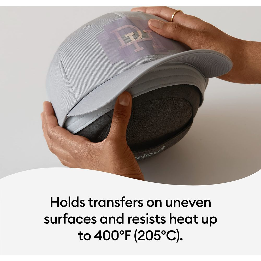 Mani tengono un cappellino grigio con un trasferimento applicato. Sotto c'è un inserto scuro.