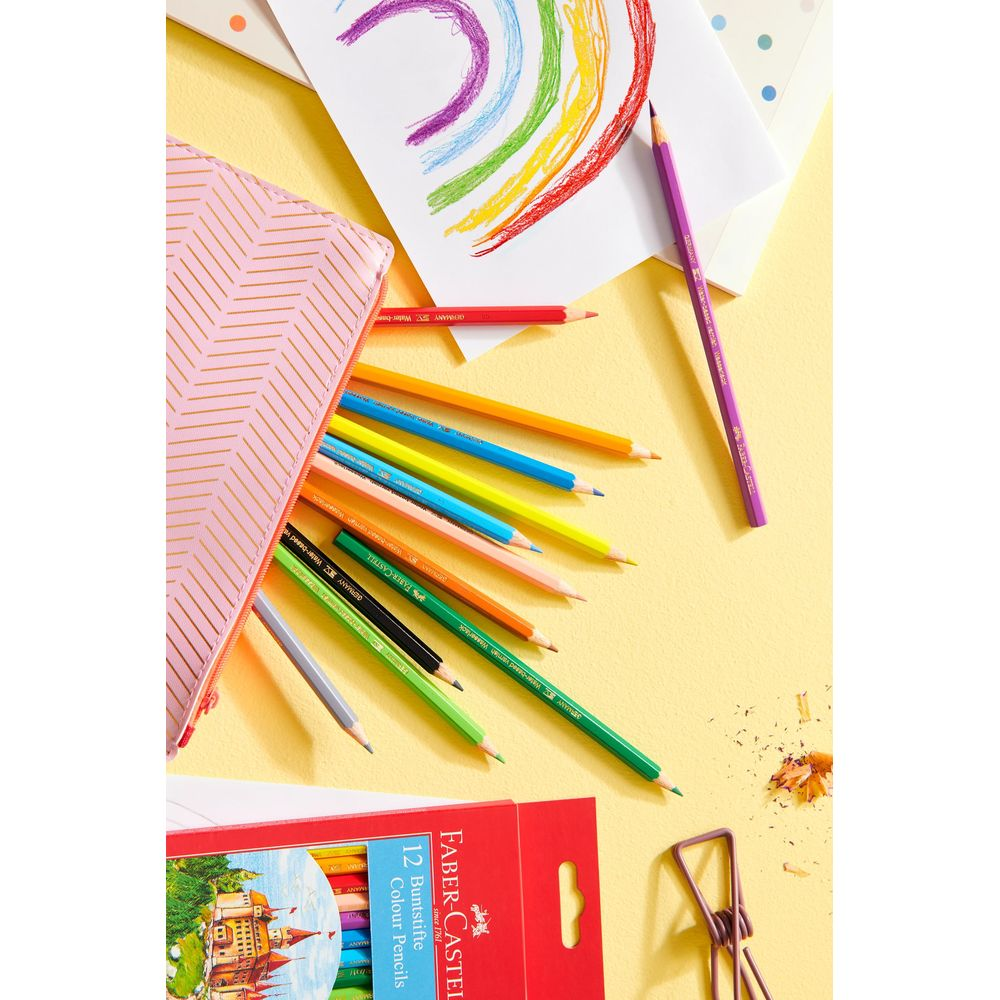 Bunte Stifte, ein Regenbogen und eine Packung Stifte auf gelbem Hintergrund.