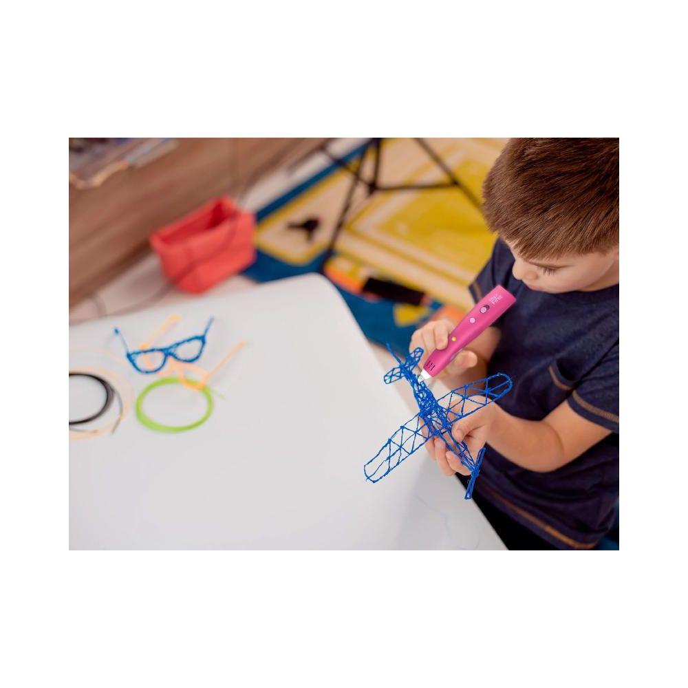 Ein Junge benutzt einen 3D-Stift, um ein blaues Flugzeug zu bauen. Mehrere Stifte liegen auf dem Tisch.