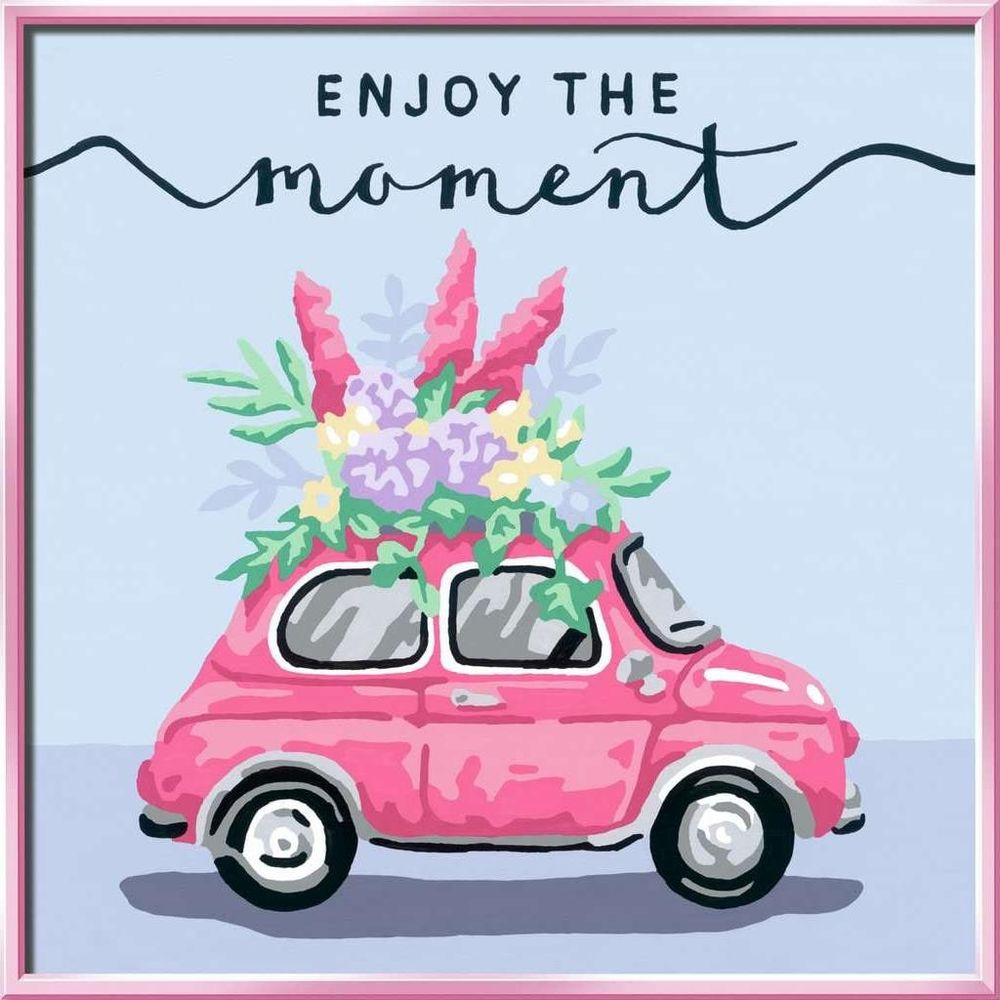 Un'auto vintage rosa con fiori in cima e la scritta "Goditi il momento".