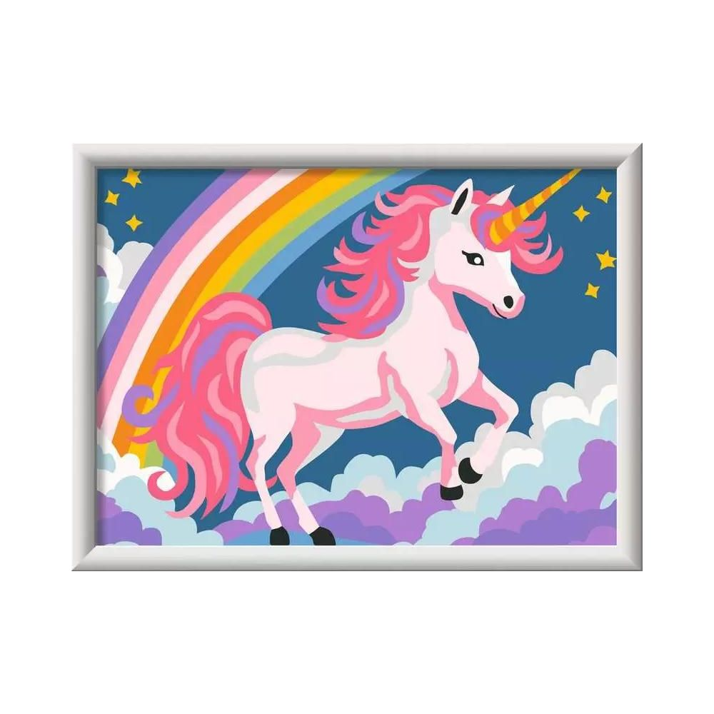 Un unicorno rosa con criniera rosa sta sulle nuvole davanti a un arcobaleno.