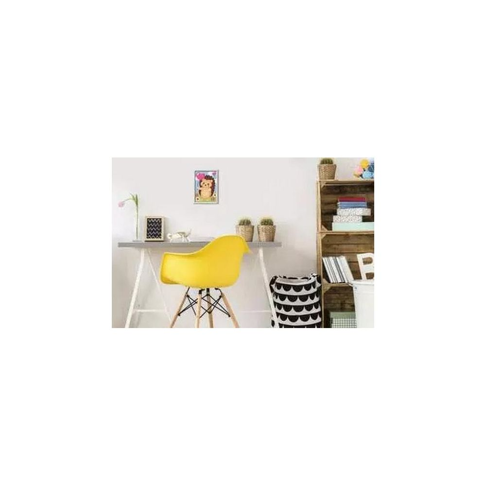 Una silla amarilla junto a un escritorio con un cuadro de erizo. Una estantería tiene libros.