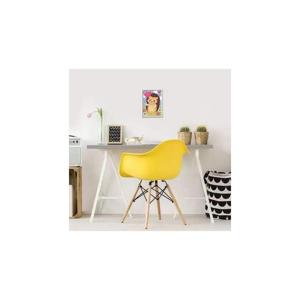Un cuadro de un erizo con un globo en forma de corazón cuelga sobre un escritorio con silla amarilla.