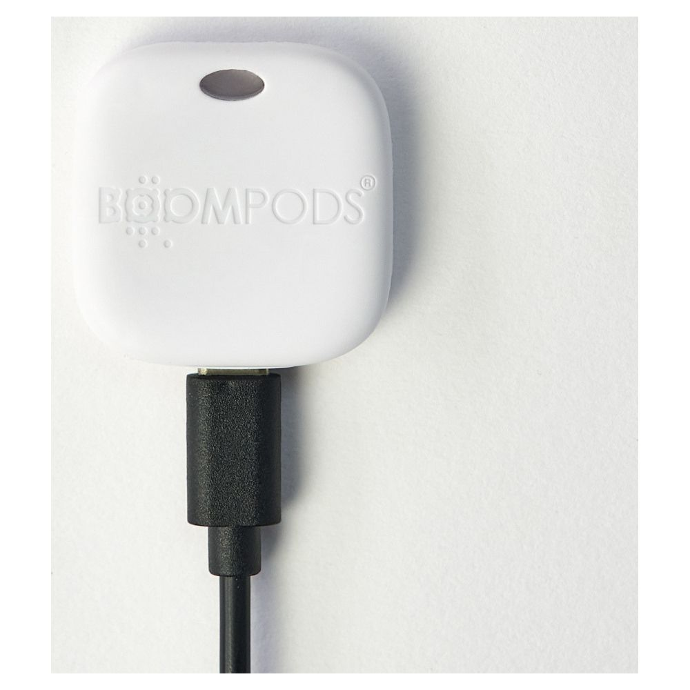 Dispositivo bianco Boompods con cavo di ricarica nero su sfondo bianco.