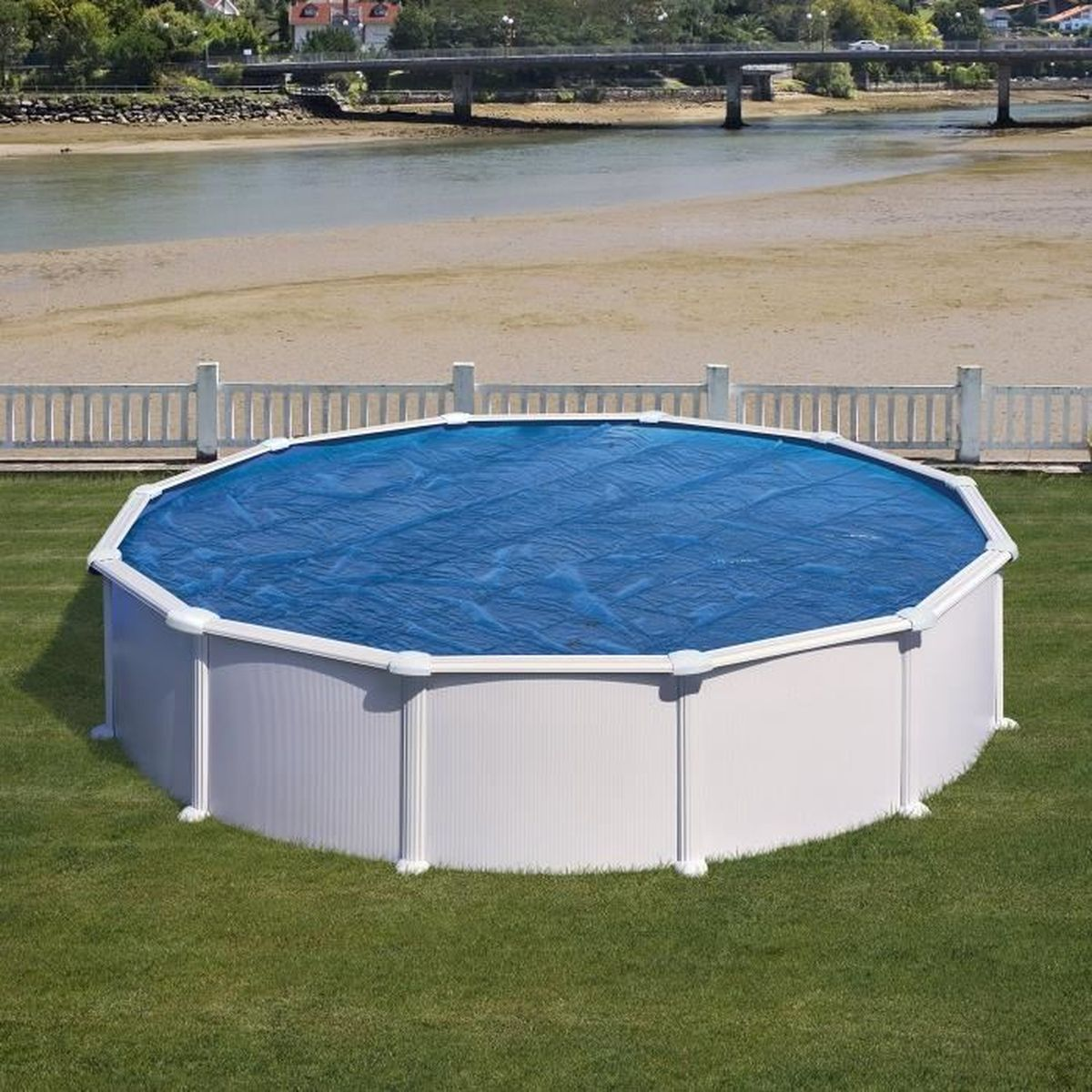Ein achteckiger Pool über dem Boden mit blauer Solarfolie steht auf grünem Rasen.