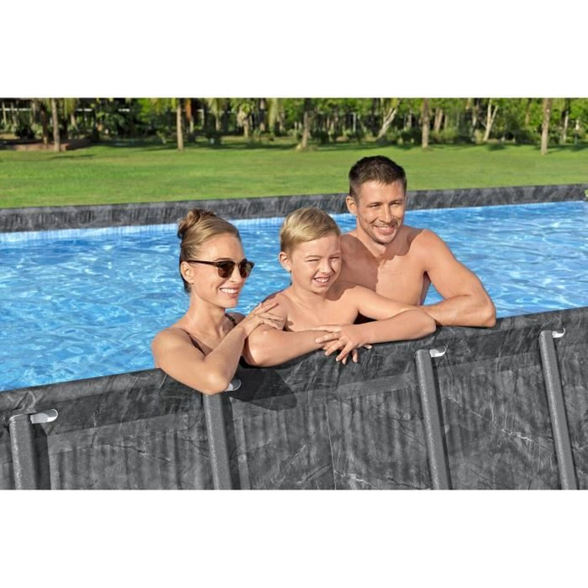 Una famiglia (uomo, donna, bambino) sta in una piscina.