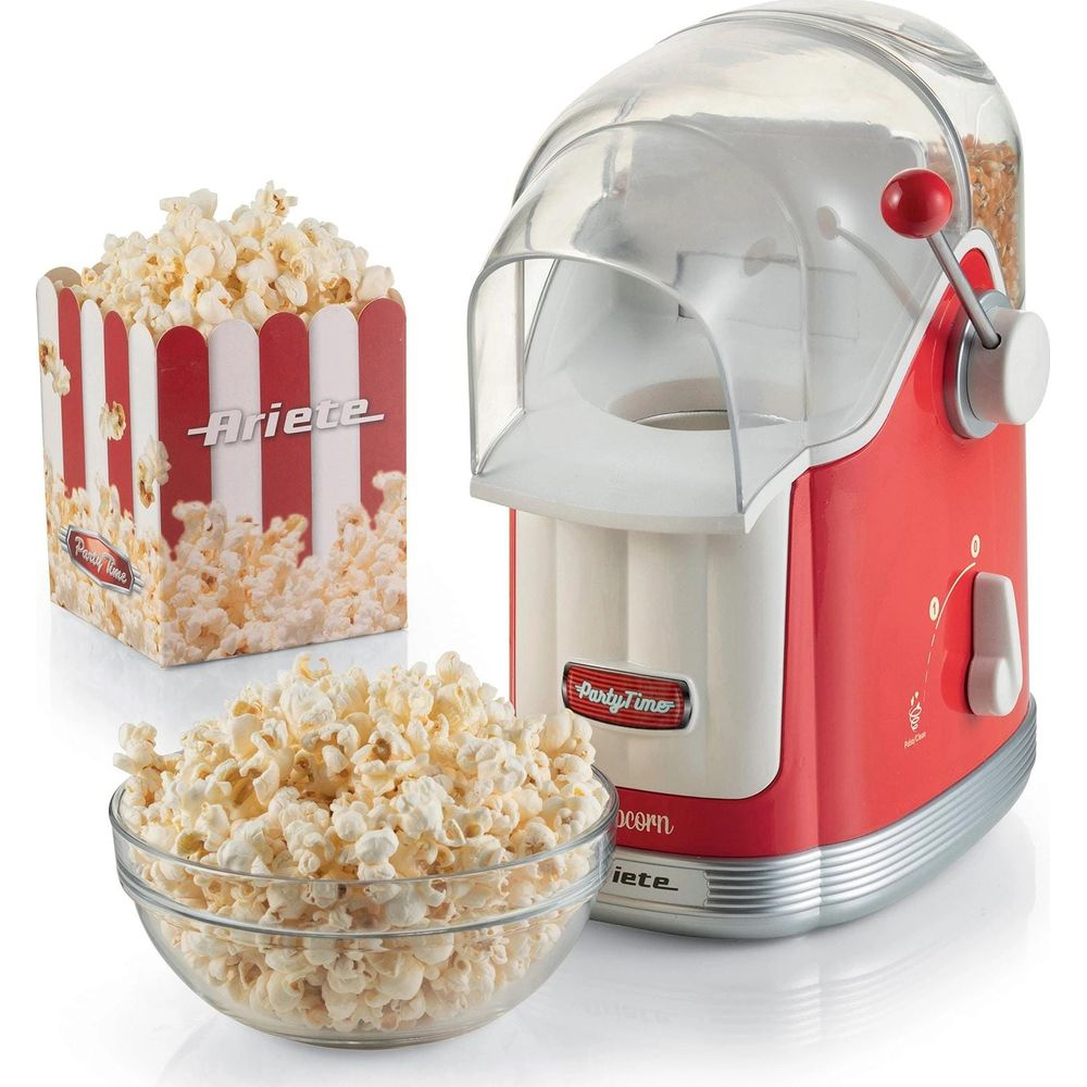 Een rode en witte popcornmachine met een glazen kom en bakje popcorn.