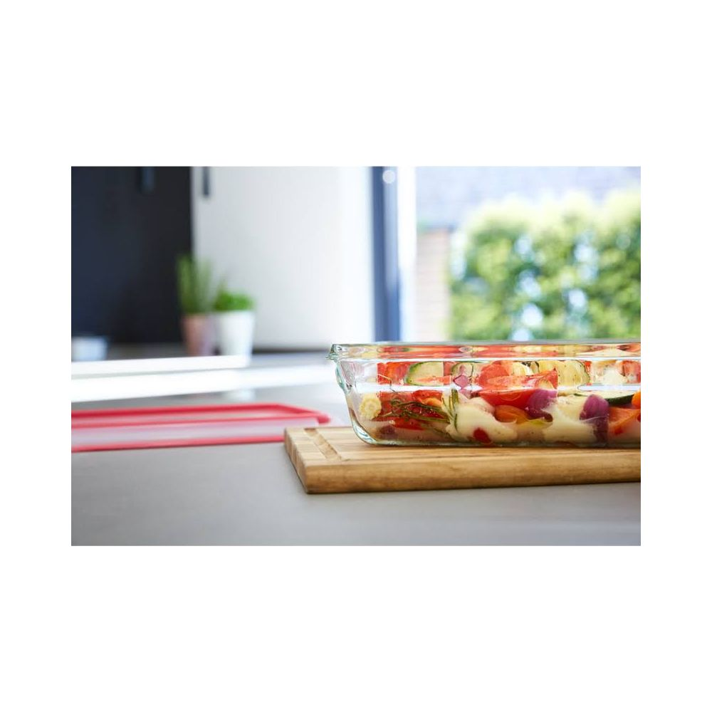 Glasform mit Gemüse auf einem Holzbrett in einer Küche.