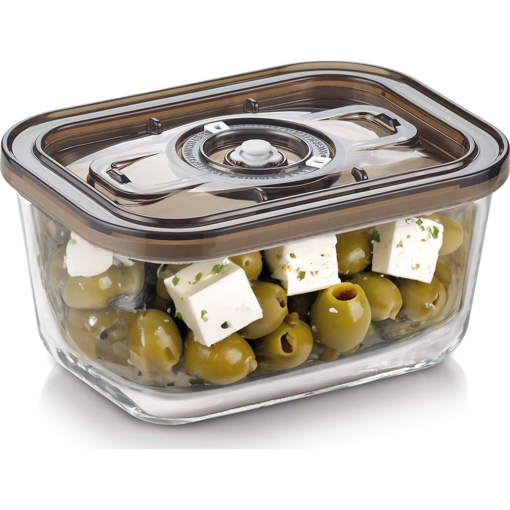 Olive verdi e cubetti di formaggio bianco in un contenitore di vetro con coperchio marrone.