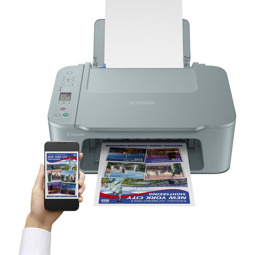 Een grijze Canon Pixma printer drukt een brochure over sightseeing in New York. Een telefoon toont dezelfde brochure.