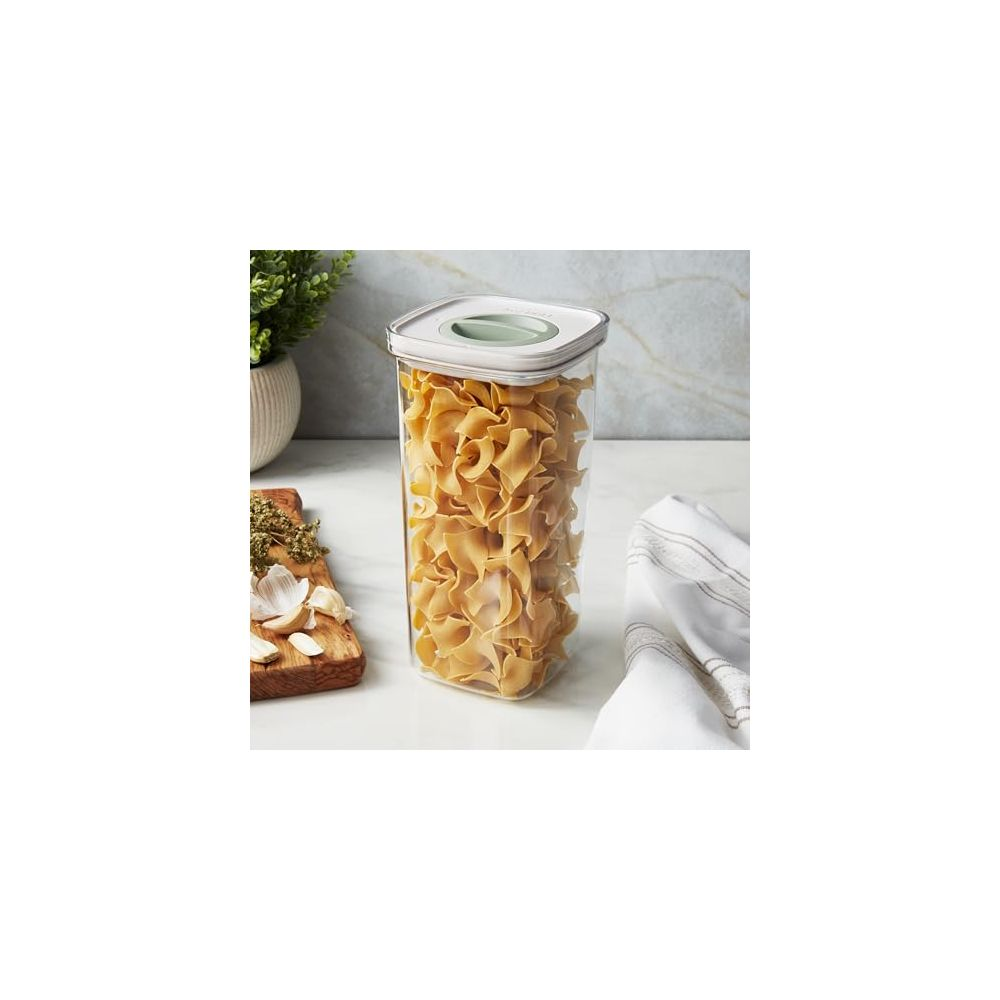 A rectangular container filled with pasta and a green lid.