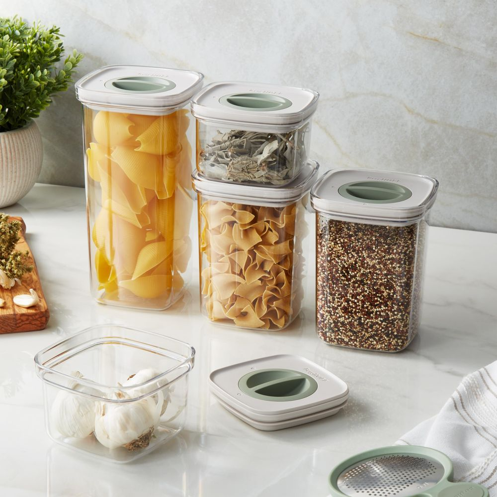 Kitchen containers with pasta, herbs, quinoa, and garlic.