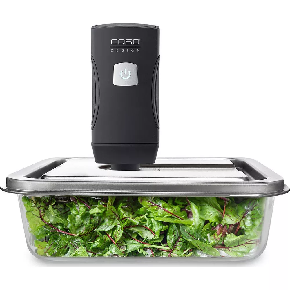 Ein schwarzes Vakuumiergerät über einer Glasbox mit Salat.