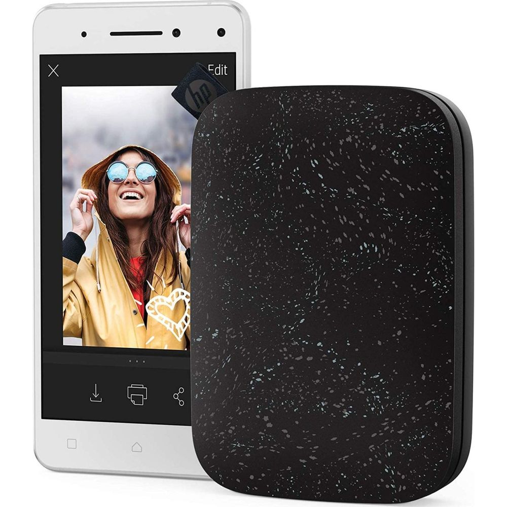 Smartfon wyświetla zdjęcie uśmiechniętej kobiety w żółtej kurtce obok czarnej drukarki.