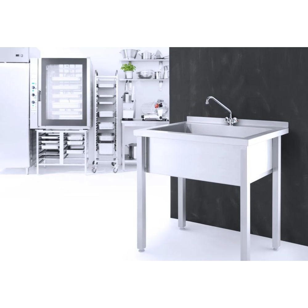 Un lavello in acciaio inox davanti a una parete scura. Sullo sfondo, un forno e mensole.