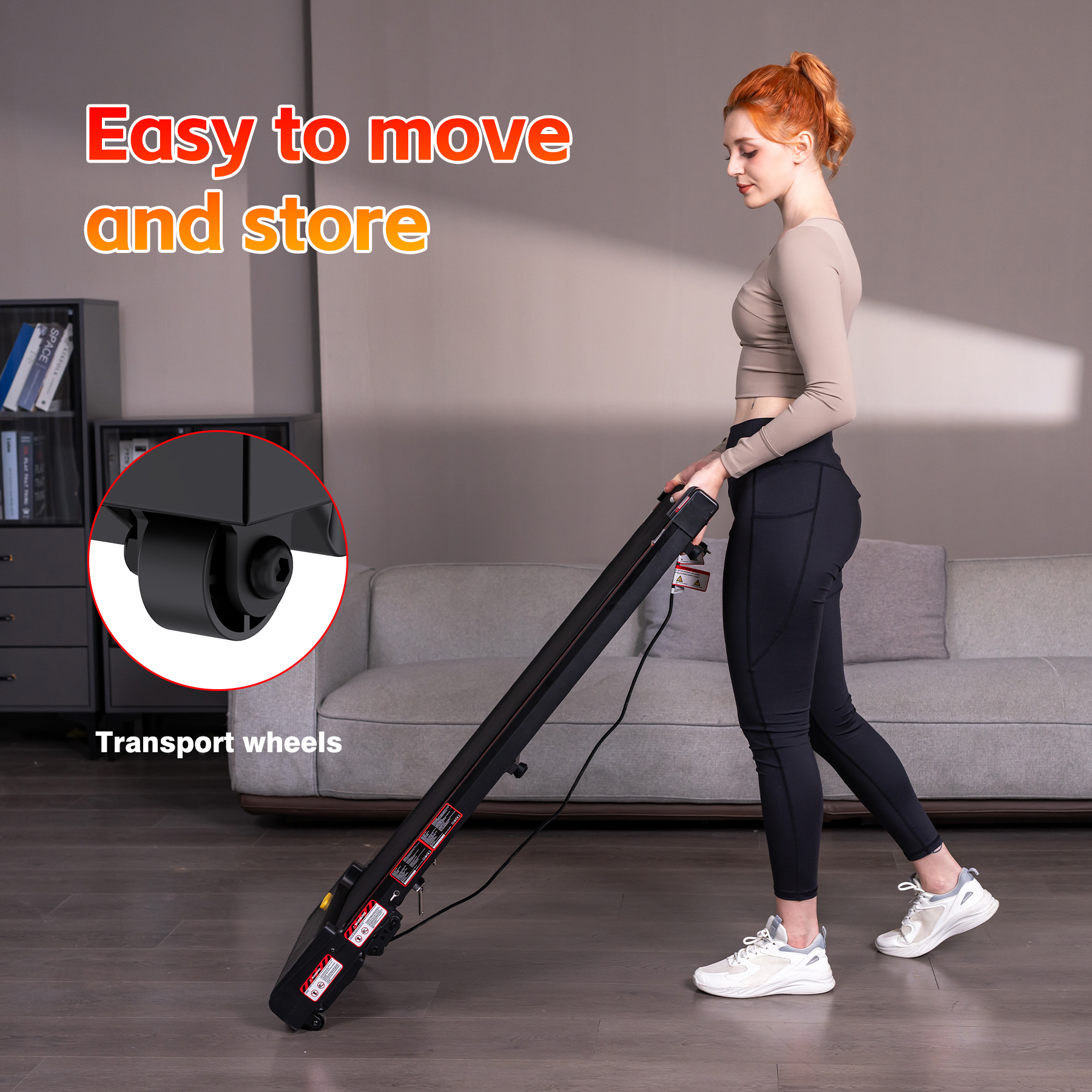 A woman with red hair pushes a black treadmill with transport wheels.
