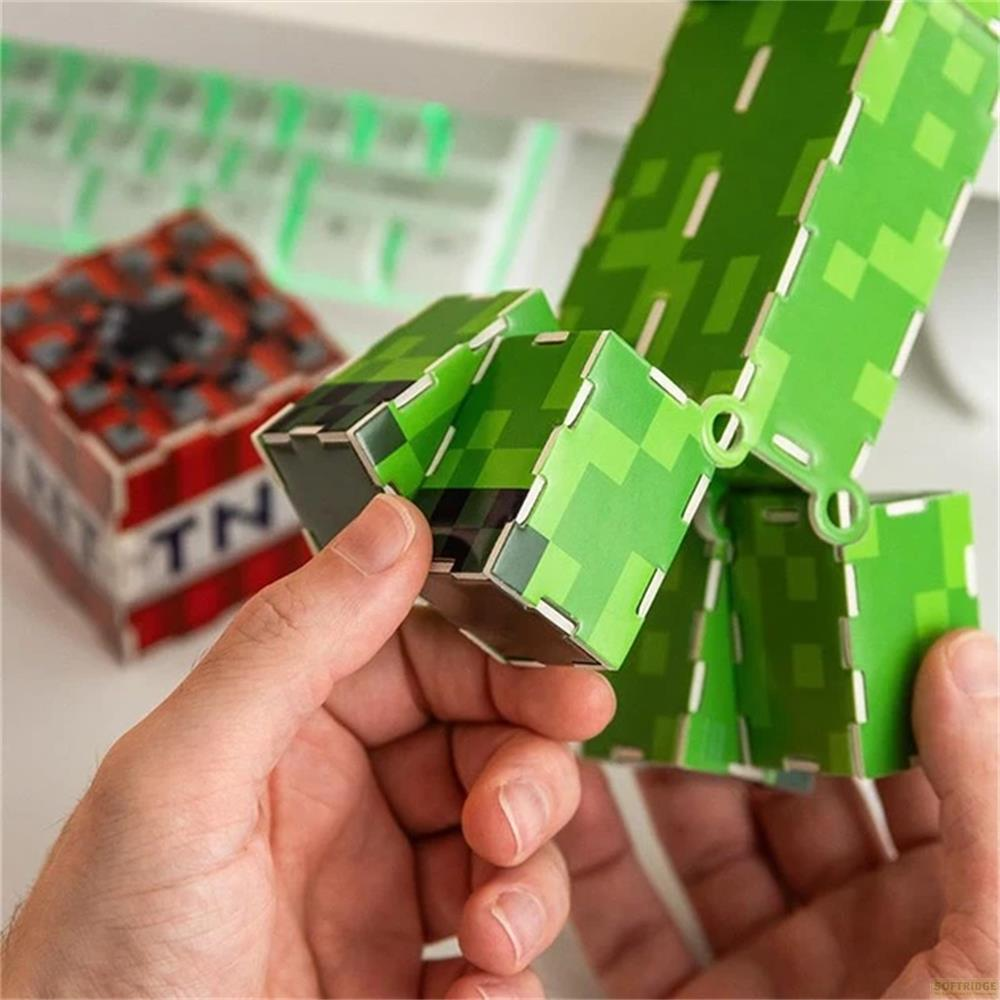 Ein grünes Minecraft-Creeper-Modell wird von Händen gehalten. Im Hintergrund ein TNT-Block.